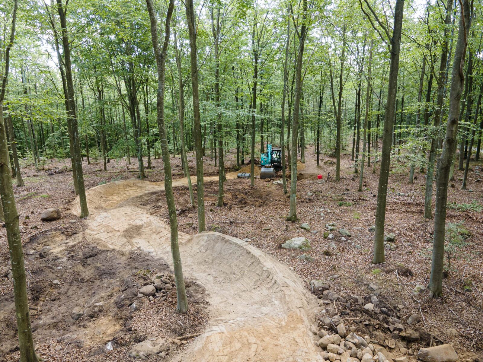 Grävmaskin bygger MTB led i skogen